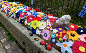 A knitted snail can be seen perching on the wall of the arboretum