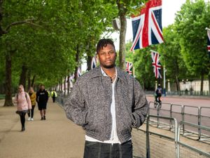 Victor Ray on a tree-lined street with Union flags