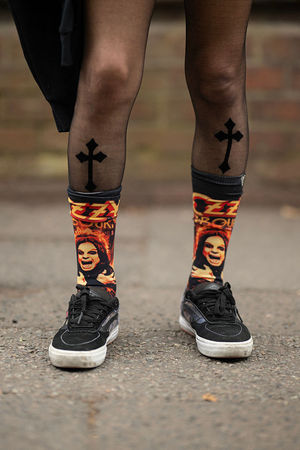 Ozzy Osbourne-themed socks worn by music fan Jen Sanchez as she arrives to attend British rock band Black Sabbath's "Back to The Beginning" concert, Ozzy Osbourne's final ever gig as Black Sabbath's frontman at Villa Park in Birmingham, central England on July 5, 2025. Osbourne, who revealed in 2020 that he has Parkinson's disease, will join Tony Iommi, Geezer Butler and Bill Ward for the all-day "Back To The Beginning" show in Birmingham, central England, where the heavy metal giants formed in 1968. (Photo by Oli SCARFF / AFP) (Photo by OLI SCARFF/AFP via Getty Images)          