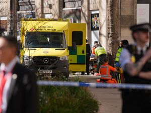 Police officer, incident tape and ambulance at the scene of the van crash