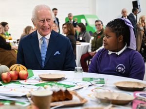 The King chats with a local schoolgirl during a visit to the Coronation Food Project's hub in Deptford, south-east London