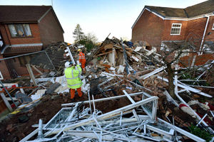 Workers at the devastated house