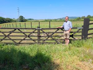 The Rev Paul Cawthorne with the proposed battery site behind him. Picture: LDRS