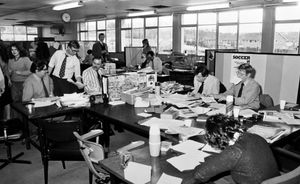 The Shropshire Star sub editors' desk in the 1980s headed by Alan, who is seated and with a moustache and striped shirt.
