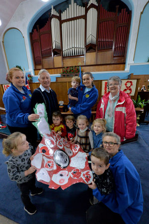 2018 poppy display at Bourne Methodist Church, Hednesford Road, Heath Hayes. Pictured inside the church are children from Smiley Faces nursery who made a giant poppy. Adults (left to right) Zoey Marklew, David Strickland, Jess Monks, Margaret Strickland and Lisa Gibson