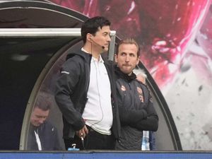 Harry Kane, right, stands on the sidelines