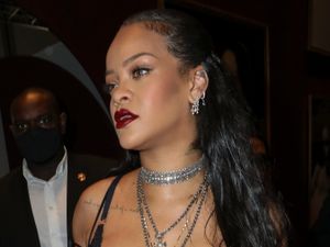 Supporting image for story: Rihanna cradles baby bump in sheer black dress at Dior show