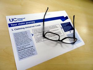 A Universal Credit application form with a pair of glasses sitting on top of it