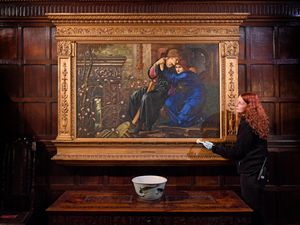 Lily Purslow stands next to 'Love Among the Ruins' by artist Sir Edward Burne-Jones.