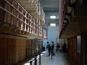 People tour the main cell house on Alcatraz Island in San Francisco