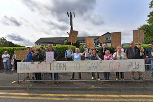The protestors stood outside the pub with the banner which invited motorists to honk their support