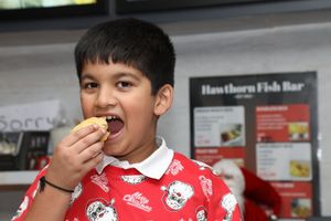Jasraaj eating Batterd Mince Pies. Palvinder Singh owner of Hawthorn Fish Bar in Birmingham  deep fries mince pies as well as pigs in blankets. 