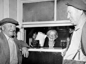 Shrewsbury, 1950s–60s: unwinding with a pint at a busy serving hatch, location and people unknown.