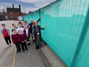 Headteacher Helen Tomlinson and chair of governors Mark Westwood with pupils next to the new fence