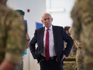 John Healey pictured standing among soldiers