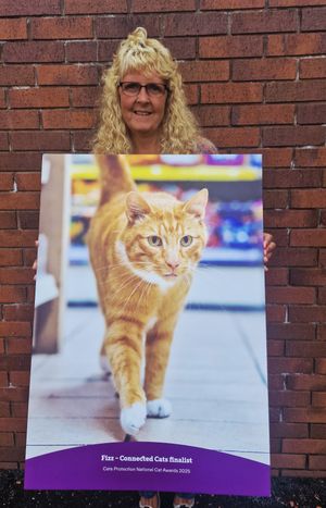 Briony with a giant poster of award winner Fizz Wanderer