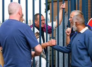 John Hill greets former colleagues through the gate