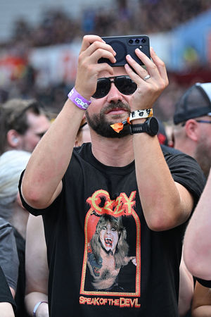 A fan takes a photo while watching support acts, during British rock band Black Sabbath's "Back to The Beginning" concert, Ozzy Osbourne's final ever gig as Black Sabbath's frontman at Villa Park in Birmingham, central England on July 5, 2025. Osbourne, who revealed in 2020 that he has Parkinson's disease, will join Tony Iommi, Geezer Butler and Bill Ward for the all-day "Back To The Beginning" show in Birmingham, central England, where the heavy metal giants formed in 1968. (Photo by ANDY BUCHANAN / AFP) (Photo by ANDY BUCHANAN/AFP via Getty Images)          