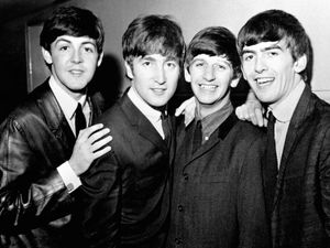 A black and white photograph of the Beatles