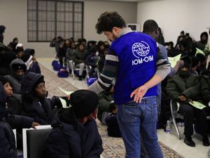 An official from the International Organization for Migration, IOM, talks to Nigerian migrants before being deported from Tripoli, Libya