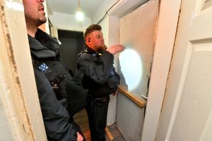Officers inspect the double layer of doors that was proving a handful to break down
