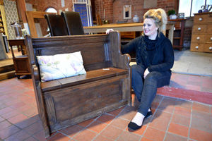 Rebecca Underwood with a church pew for sale on the website Reclamation Shop