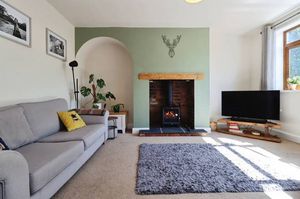 A cosy lounge with a newly installed log burner creates a warm and inviting heart to the home