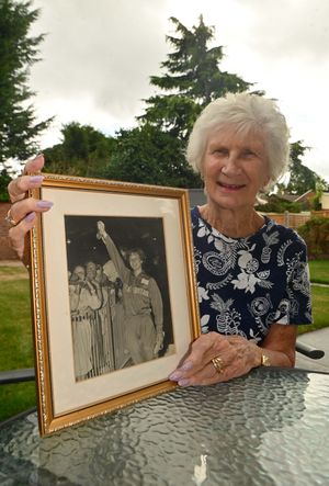 Anita smiles holding the photograph of her celebrating winning gold in Rome.