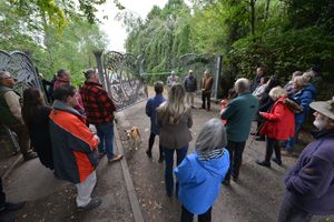 Volunteers who worked on the restoration of the gates and others look on as they are re-opened officially,