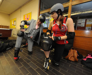 Sarah Evans shows Mark Andrews how to stand up wearing roller skates for the first time