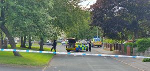 Armed officers keep an eye on the area around the flats