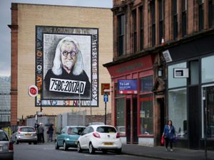 Sir Billy Connolly mural on the side of a building on a street in Glasgow