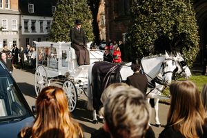 The stunning white carriage, led by two white horses.