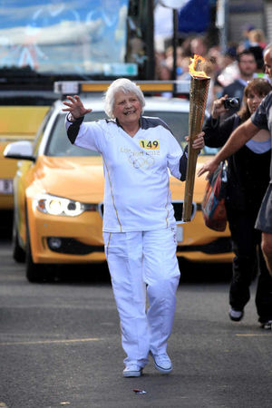 Torchbearer 149, Jessica Gripton, carries the Olympic Flame on the torch relay leg between Dudley and West Bromwich