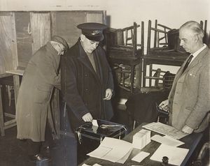 Although this picture was taken in Oakengates, voting was taking place in April 1964 following a referendum on the proposed amalgamation of Oakengates and Wellington. The photograph shows a postman voting at Hartshill polling station, watched by the presiding officer, Mr A. H. Johnstone.