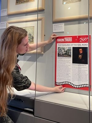 Kyla Hislop, Acting Head of Interpretation at IGMT, installing a panel of Making Tracks