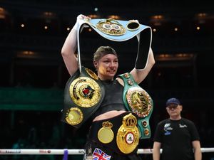 Lauren Price celebrates victory against Natasha Jonas by holding up her belts