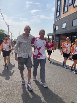 Stuart Richards carries the baton through Southwater joined by his brother Gary 