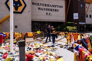 A supporter lays flowers at Molineux