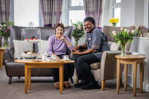 Resident and Carer at HC-One Care Home enjoying a slice of cake and coffee