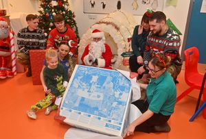 Esme Ridge, 6 and play specialists Georgia Newsome and Dawn White, with staff from RAF Shawbury opening presents for the ward