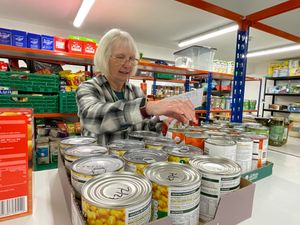 Tessa Bradley, Llandrindod Foodbank and Advice Centre Project Manager picking a food parcel.
