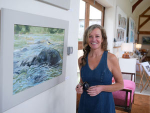 Doldowlod artist Deb L Bunker alongside her painting of a Grey Wagtail
