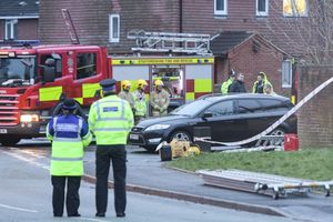 Police and firefighters stand respectfully at the scene. Picture: Caters