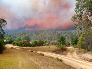 In this Dec. 30, 2019, photo provided by Siobhan Threlfall, a fire approaches the village of Nerrigundah, Australia. The tiny village has been among the hardest hit by Australia's devastating wildfires, about with two thirds of the homes destroyed and a 71-year-old man killed. (AP Photo/Siobhan Threlfall).