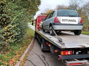 A Clio being loaded up on the back of a truck