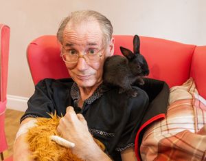 Ian Burton, 61 (Resident) with an Old English Cross Baby Rabbit
