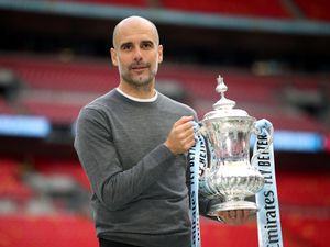 Manchester City manager Pep Guardiola holds up the FA Cup at Wembley