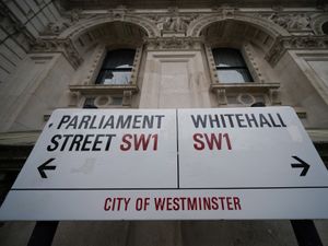 A street sign giving directions to Parliament Street and Whitehall in London