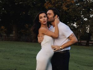 Ed Westwick hugs his wife, Amy Jackson, with one hand on her pregnancy bump